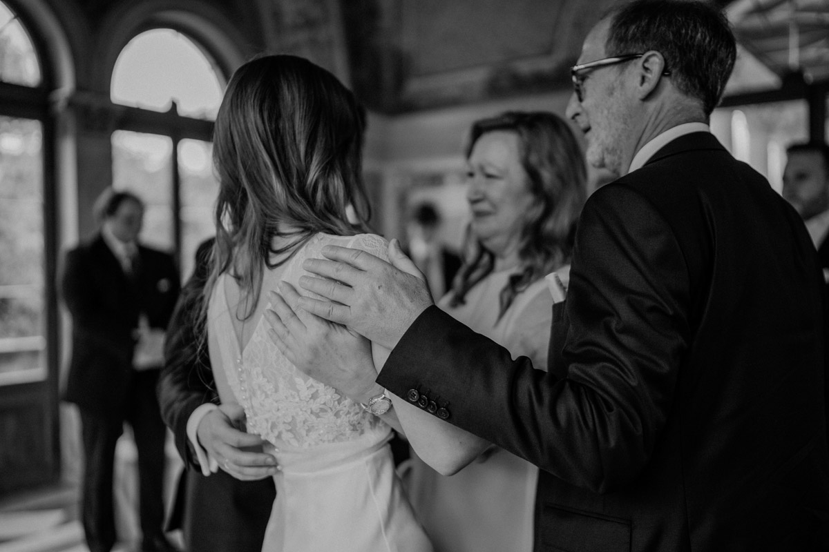 Detailaufnahme Gratulation: Hände der Gäste berühren liebevoll die Schulter der Braut