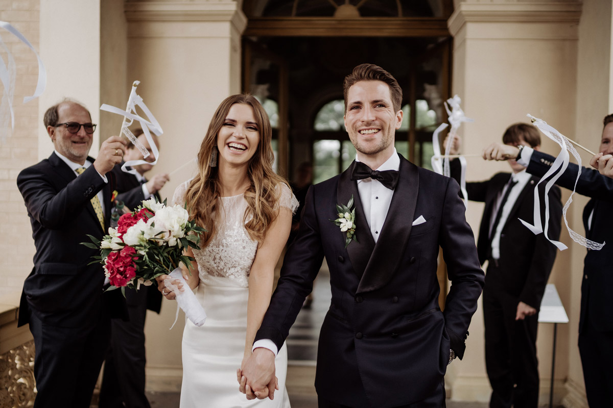 Auszug aus dem Trauraum: Paar verlässt lachend und Hand in Hand das Maurische Kabinett