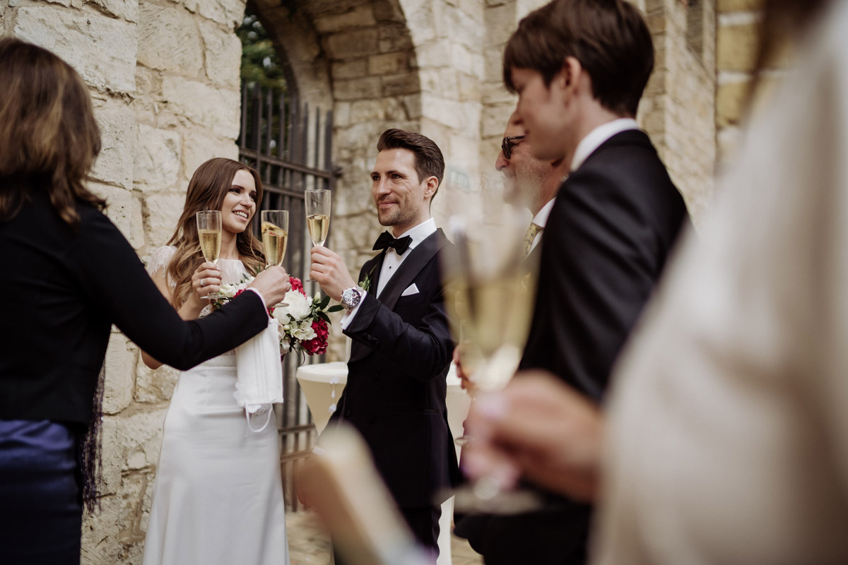 Atmosphäre beim Sektempfang: Gesellschaft steht entspannt im Säulengang des Belvedere