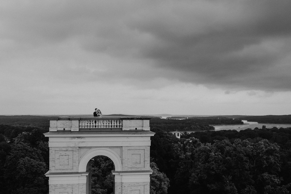 Architektur und Liebe: Kleines Brautpaar auf dem imposanten Ostturm – Schwarz-Weiß