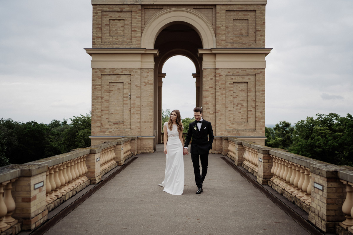 Weitwinkel-Aufnahme: Brautpaar vor dem mächtigen Rundbogen des Ostturmes