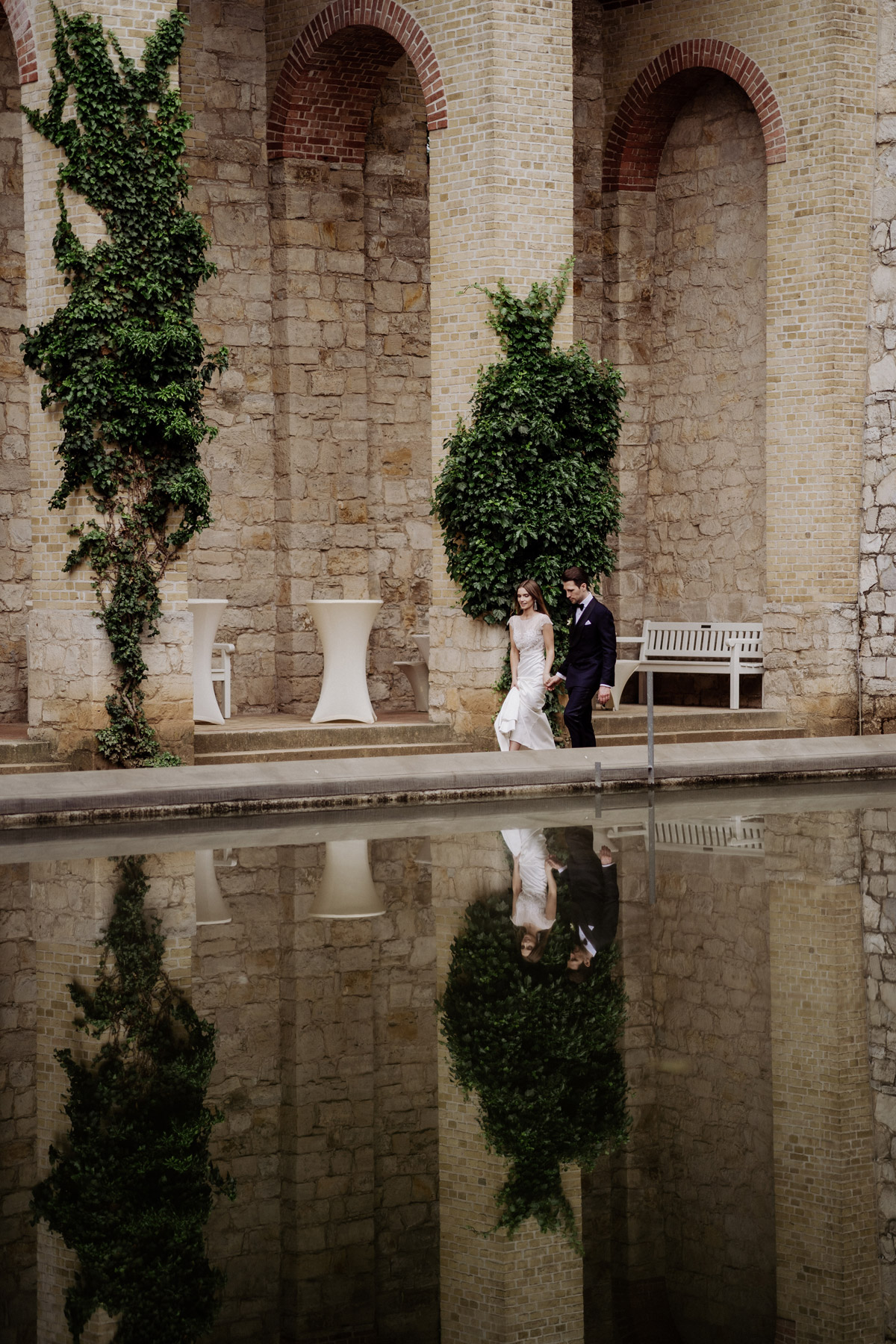 Symmetrie: Perfekte Spiegelung des Brautpaares im Wasserbecken