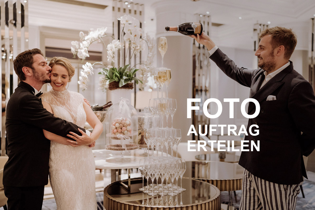 Elegantes Brautpaar füllt lachend eine Champagner-Pyramide. Klicke hier, um den Auftrag für deine Hochzeitsfotos bei deiner Hochzeitsfotografin Berlin zu erteilen.