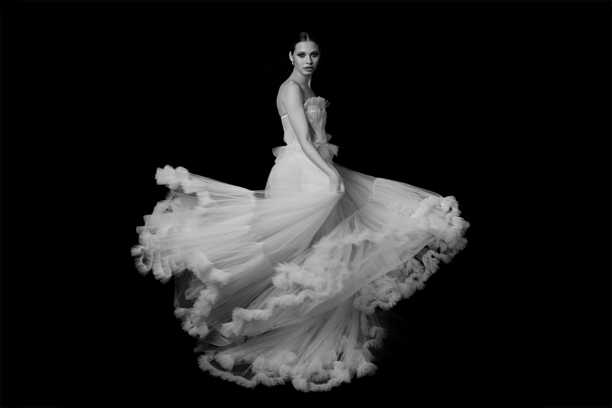 Dynamisches Brautporträt im Editorial-Stil von Wedding and Fashionphotographer Berlin vor schwarzem Hintergrund. Ein Beispiel für die künstlerische Qualität eurer Hochzeitsfotos zur privaten Nutzung.